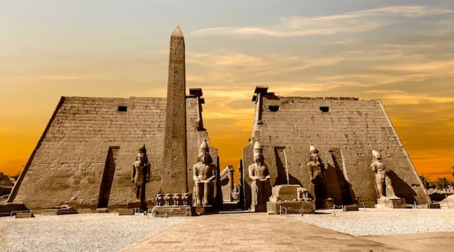 Entrance of Luxor Temple with massive statues and ancient columns in Luxor, Egypt